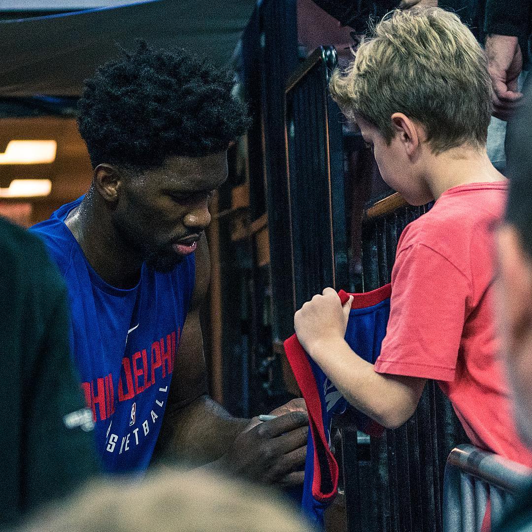 76人官方发布恩比德为小球迷签名照片